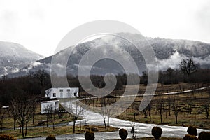 Beautiful landscape of mountains and forest with village building or old abandoned ruined brick house. Foggy forest and old buildi