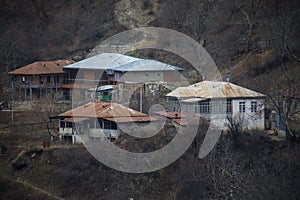 Beautiful landscape of mountains and forest with village building or old abandoned ruined brick house. Foggy forest and old buildi