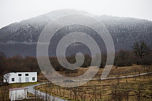 Beautiful landscape of mountains and forest with village building or old abandoned ruined brick house. Foggy forest and old buildi