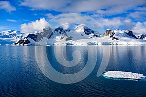 Antarctic landscape with mountains, glacier and ice floe oin dark blue water of Lemaire Channel near Paradise Bay, Antarctica