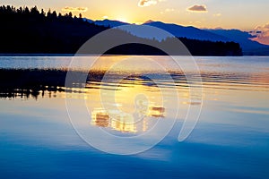 Beautiful landscape with mountains and lake at dawn in golden, blue and purple tones. Slovakia, Central Europe, Liptov.