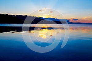 Beautiful landscape with mountains and lake at dawn in golden, blue and purple tones. Slovakia, Central Europe, region