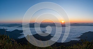 Beautiful landscape on the mountains at sunrise. Spectacular view in foggy valley covered forest under morning sky. Panorama