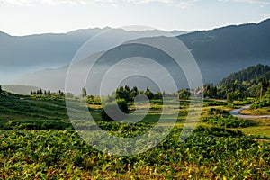 Beautiful landscape with mountains and a valley with house and road at sunset with blue sky. View of the valley in Georgia