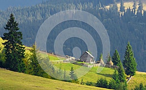 Beautiful landscape with an old wooden cottage on a mountain slope