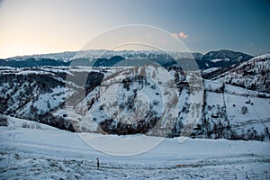 Beautiful landscape of Piatra Craiului Mountains at sunset in a cold and sunny day during winter season