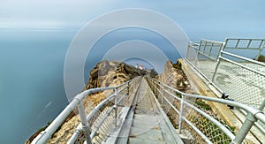 Beautiful landscape, Point Reyes lighthouse on the rocky coast of the Pacific Ocean, a long staircase leads to it. California, USA