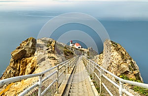 Beautiful landscape, Point Reyes lighthouse on the rocky coast of the Pacific Ocean, a long staircase leads to it. California, USA