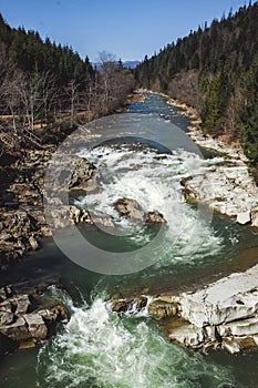 A beautiful landscape with the rapid on the mountain river in early spring