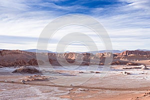 Beautiful landscape with red rocks, clouds and blue sky at Valle de La Luna during sunset