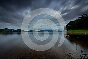 Beautiful landscape of reservoir in the morning. Mountain and green tree forest. Cloudy sky. Clear water in the river. Fresh air.