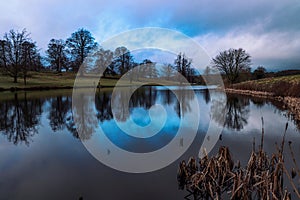 Beautiful landscape of Ripley lake under a blue cloudy sky in England.