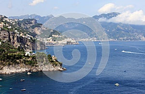 Beautiful landscape with sea, rocks and traditional Italian architecture at sunset.