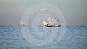 Beautiful landscape of seaside and fishermen. African males working in the ocean on sailboats, local business.