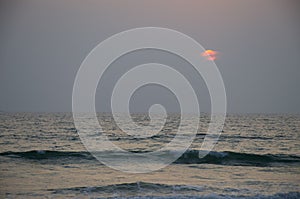 Beautiful landscape sunset with at the sea blue with the red sun and waves