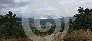 Beautiful landscape of trees and mountains under a cloudy sky in Iballa village, Albania.