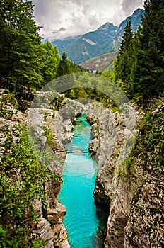 Beautiful landscape with turquois blue creek river with rocks, trees and mountains