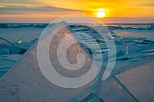 Beautiful landscape of Uzury bay with ice hummock rising above the frozen lake of Baikal at sunrise.