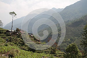 Beautiful landscape view of a forested mountain range with old rural houses on a slope in Nepal
