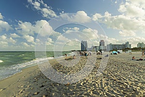 Beautiful landscape view of Miami South  Beach coast line. Sand beach, Atlantic Ocean, people and high buildings on blue sky.