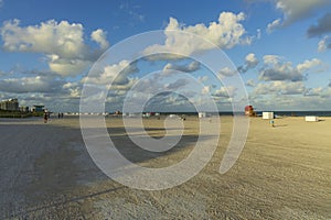 Beautiful landscape view of Miami South  Beach coast line. Sand beach, Atlantic Ocean, people and high buildings on blue sky.