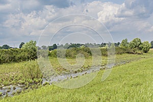 Beautiful landscape view with narrow water channel at the field