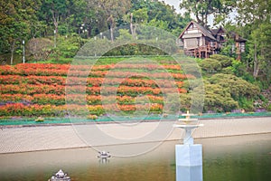 Beautiful landscape view of red flower garden and the small cottage in the forest at Bhubing palace, Chiang Mai, Thailand.