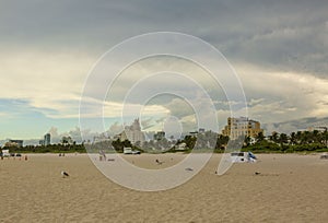 Beautiful landscape view of sunset Miami South  Beach coast line. Sand beach, Atlantic Ocean, people  on blue sky background.