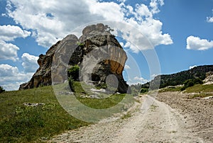 Beautiful landscape with a winding dirt road under blue skies wi