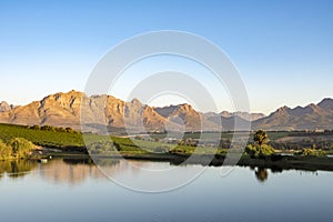 Beautiful Landscape Winelands, South Africa. Vineyards of Winery Asara, Stellenbosch, South Africa. Mountains reflecting in lake. photo