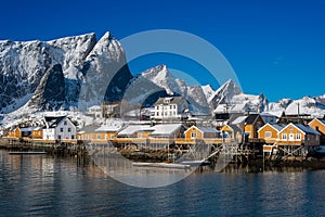 Beautiful landscape from yellow rorbu houses of Sakrisoy fishing village under blue sky in winter season, Lofoten islands, Norway