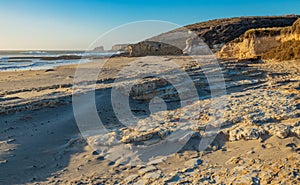 Beautiful landscapes of the Pacific coast, beach with human footprints, rocks, waves, sky, sun. Santa Cruz and Davenport have some