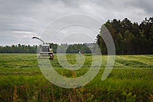 Beautiful lansdscape with haymaking or combine a field photo
