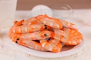 beautiful large boiled tiger prawns on a white plate on the kitchen table
