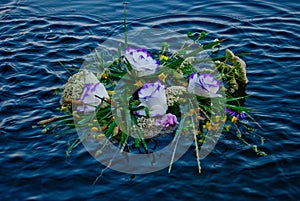 Beautiful large bouquet of flowers wreaths floating on the river on the waves on the water of Ivan Kupala