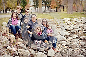 Beautiful large family sitting on rocks