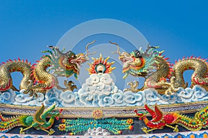 Beautiful large grimace dragons crawling on the decorative tile roof in Chinese temples. Colorful roof detail of traditional Chine