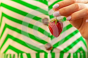 Beautiful large red strawberry in a hand