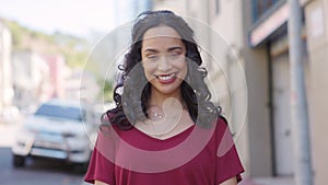 Beautiful latin woman in city street looking at camera