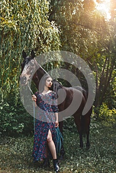 Beautiful Latin woman in dress and her lovely horse walk in the forest. love animals concept. love horses