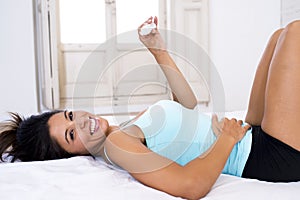 Beautiful latin woman holding pregnancy test looking and finding positive result smiling happy and excited