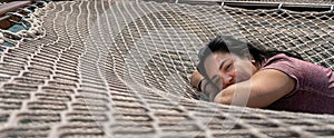 beautiful Latina adult woman resting on hammock and smiling