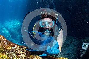 Beautiful latina diver girl while touching a fish