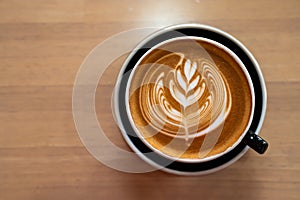 Beautiful of Latte art coffee cup on wooden table