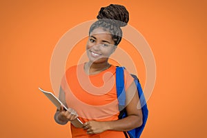 Beautiful laughing african american female student with backpack and paperwork