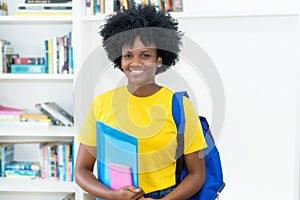 Beautiful laughing african american female student with yellow shirt