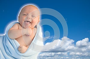 Beautiful Laughing Baby Boy Wrapped in His Blanket on a Blue Sky