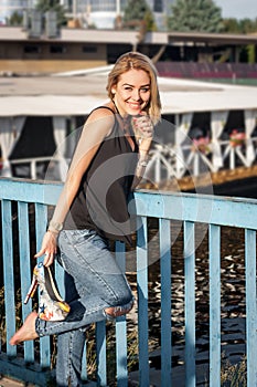 Beautiful laughing blonde standing on a bridge