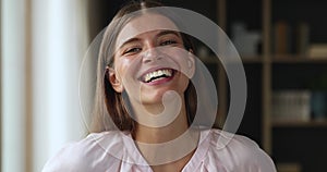 Beautiful laughing female teenager looking at camera in joyful mood