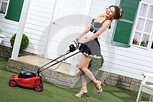 Beautiful laughing housemaid with lawn mower